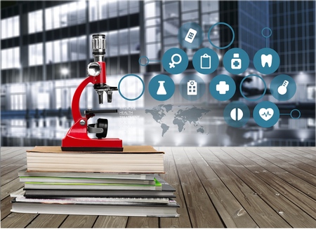 Color photo of a microscope on stack of booksの写真素材