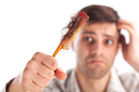 Man with a comb and problem hair on white backgroundの写真素材