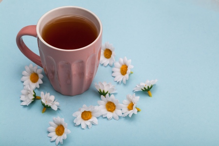 Morning Cup of coffee and a beautiful roses flowers on light background, top view. Cozy Breakfast. Flat lay style.の写真素材