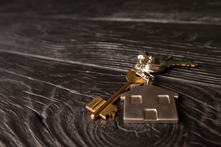 Bunch of keys lies on a wooden table.の写真素材