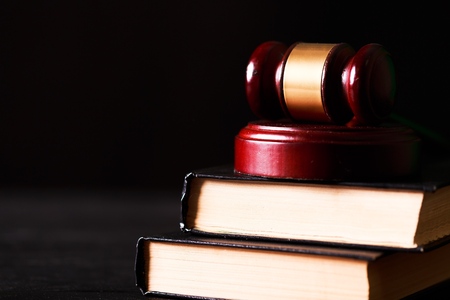 Law concept - Open law book with a wooden judges gavel on table in a courtroom or law enforcement office isolated on white background. Copy space for textの写真素材