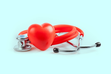 Red heart and a stethoscope on desk