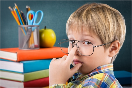 Thoughtful boy funny portrait with abstract idea clouds on chalkboard