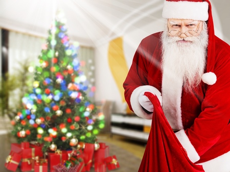Cheerful Christmas Santa Claus Holding Bag of Presents, Copy Spaceの写真素材