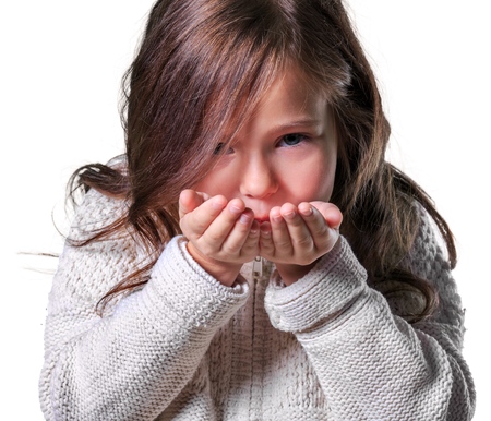 Little girl in  warm clothes making air kissの写真素材