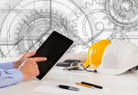 hand of architect working on table with tablet computer and working tool equipment against...