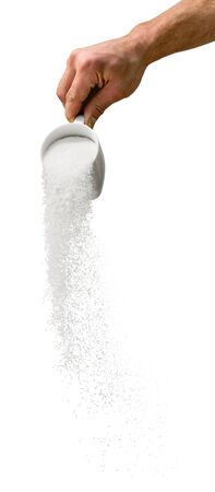 Hand Holding a Cup and Sprinkling Some Powderの写真素材