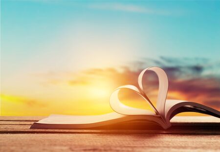 Heart from a book on sunset backgroundの写真素材
