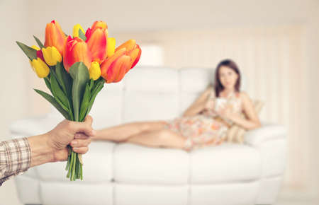 Hand holds bouquet flower for womanの写真素材