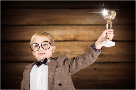 elementary school boy receiving a trophy in classroom with teachers and classmateの写真素材