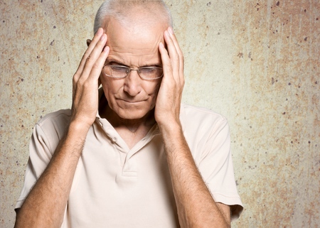 Old man holds on headの写真素材