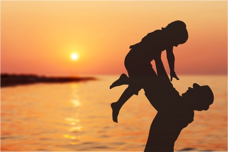 Father and son playing on the beach at the sunset time. Concept of friendly family.の写真素材
