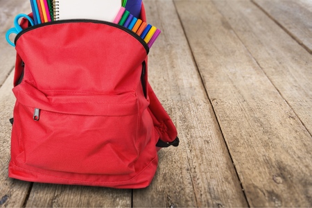 Purple backpack with school supplies isolated on whiteの写真素材