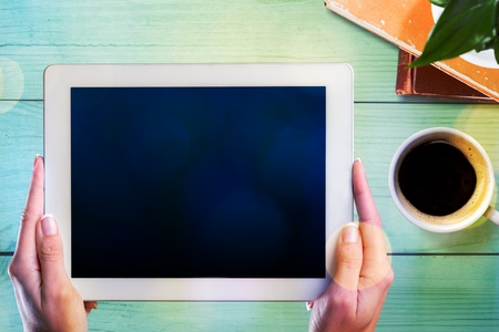 female hands holding a tablet touch computer gadget with isolated screenの写真素材