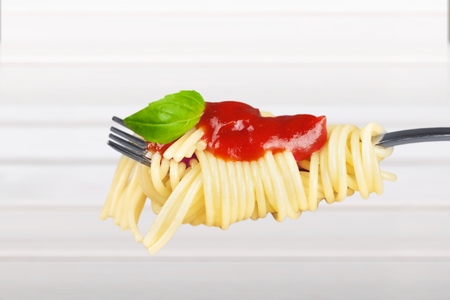 Swirls of cooked spaghetti with fork
