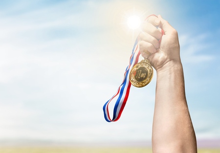 man hand holding golden medalの写真素材