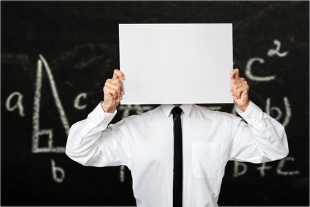 Young businessman holding card with a angry face on it isolated on gray background