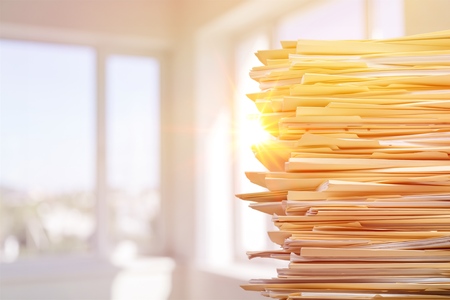 Stack of report paper documents in office