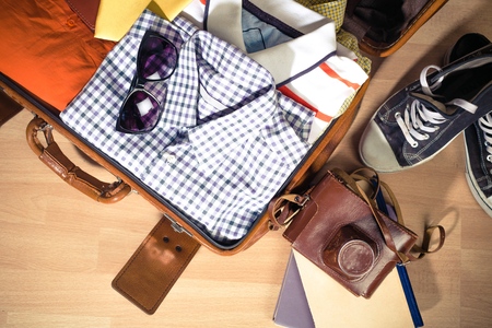 Vintage suitcase open on a wood floor in an empty roomの写真素材