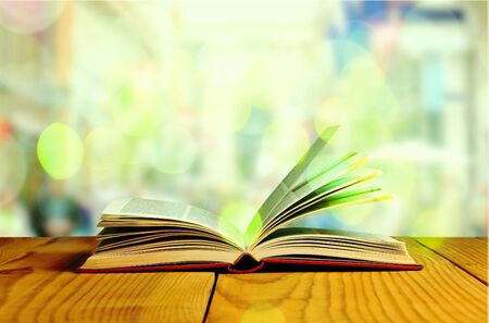 Open book on wood planks over abstract light backgroundの写真素材