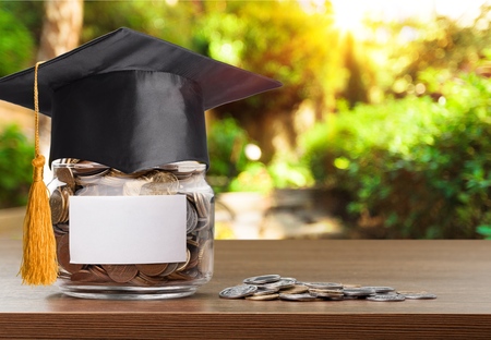 Coins money in bottle and graduation cap