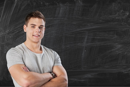 young caucasian teacher portrait with blackboard backgroundの写真素材