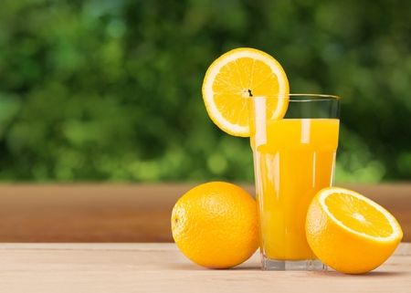 Fresh orange juice on wooden table over grunge backgroundの写真素材