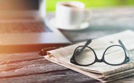 Newspaper with computer on tableの写真素材