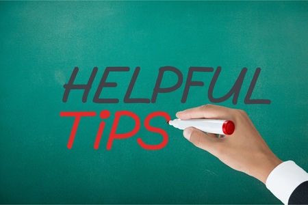 Hand writing Helpful Tips with black marker on transparent wipe board.の写真素材