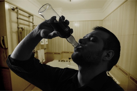 Silhouette of man drinking alcohol, close up