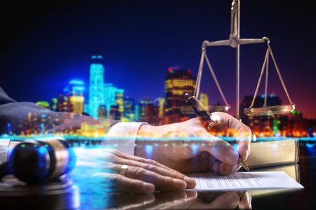 Businessman and wooden gavel on city backgroundの写真素材