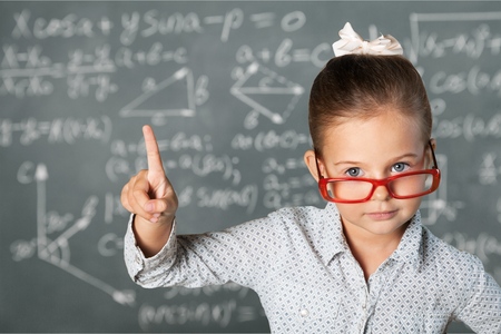 school girl near blackboard acting like teacherの写真素材