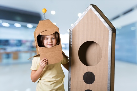 child is dressed in an astronaut diy costume made with boxの写真素材