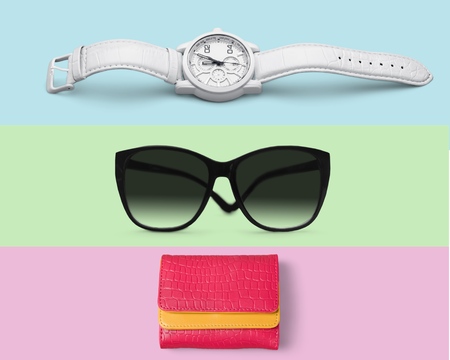 Flat lay fashion set: blue watch, pink purse and yellow sunglasses on yellow, pink and mint background in pastel colorsの写真素材