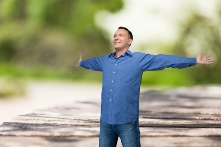 Happy young man with hands out stretchedの写真素材