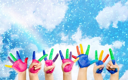 painted childrens hands in different colors with smiliesの写真素材