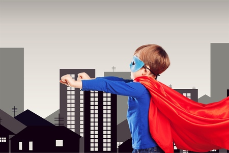 Superhero kid against blue sky background. Girl power conceptの写真素材