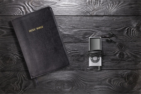 Contemporary image of a Bible with headphones.  Hearing the voice of God concept.の写真素材