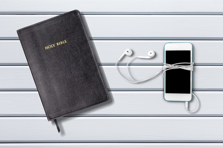 Contemporary image of a Bible with headphones.  Hearing the voice of God concept.の写真素材