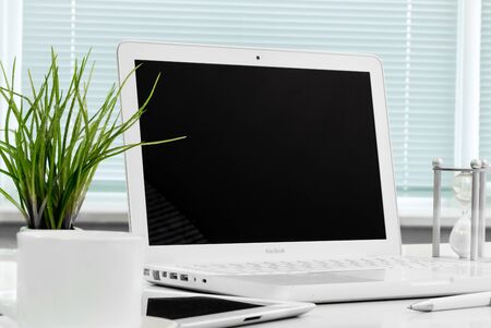 Office workplace with open laptop mockup tablet computer and smartphone on the wooden desk. For design presentation or portfolio. All devices in full focus.のeditorial素材
