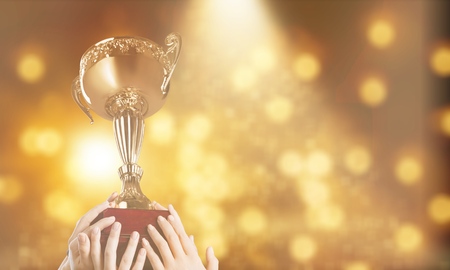 Man holding up a gold trophyの写真素材