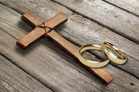 Wedding rings and cross on deskの写真素材