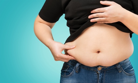 Overweight lady holding stomachの写真素材