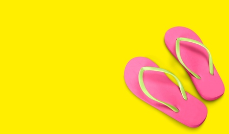 Pink Beach flip flop on yellow backgroundの写真素材