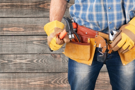 Handyman with a tool belt. Isolated on white background.の写真素材