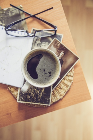 Still life details, cup of coffee and retro vintage black-and-white photos