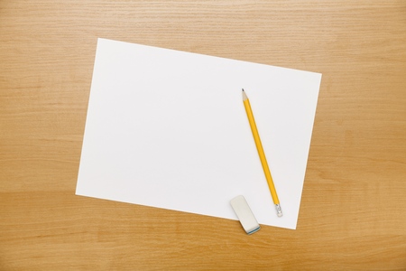 Blank paper with pen and eraser on wood tableの写真素材
