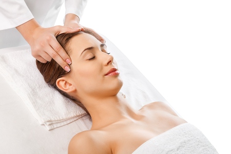 Beautiful young woman relaxing with hand massage at beauty spaの写真素材