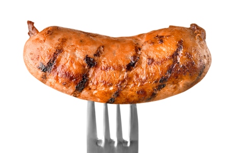 Freshly cooked sausage on fork isolated on white backgroundの写真素材