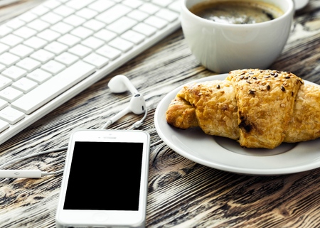 Man using smartphone, close-up, coffee and planning book on the backgroundの写真素材